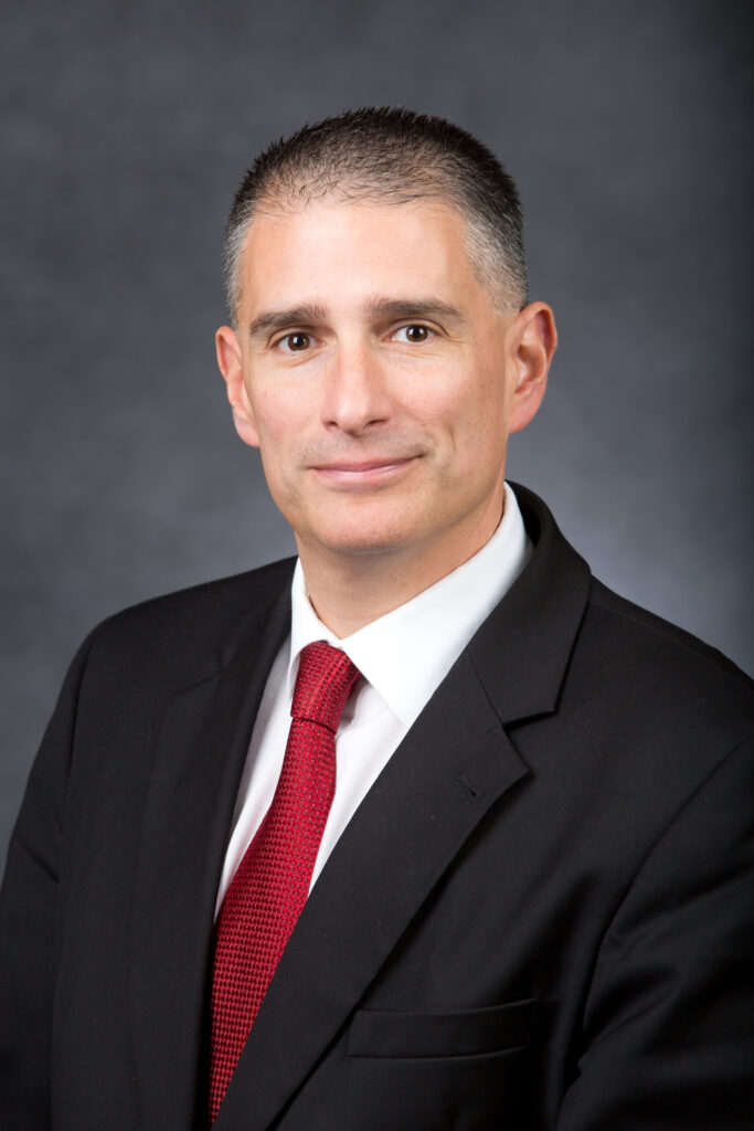 Bryan Marinelli in black suit and red tie